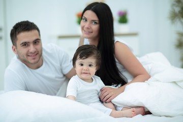 Cheerful family having fun together lying on a bed