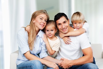 Young family at home smiling at camera