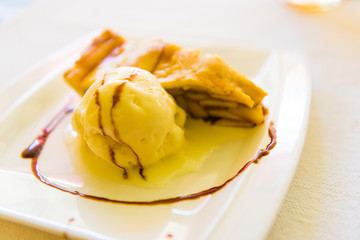 Piece of apple pie with ice cream next to it on plate, sweet dessert concept