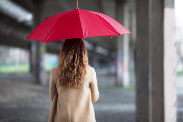 Young ginger woman with umbrella outdoors