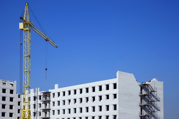 Fototapeta na wymiar Construction crane on the construction of a brick house