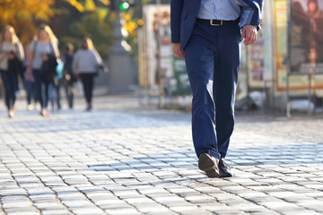 business man crossing the road at a pedestrian crossing on the pavement