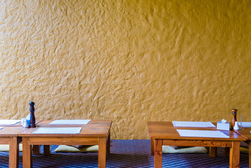 Sit on floor low dinning table at restaurant with yellow wall in background