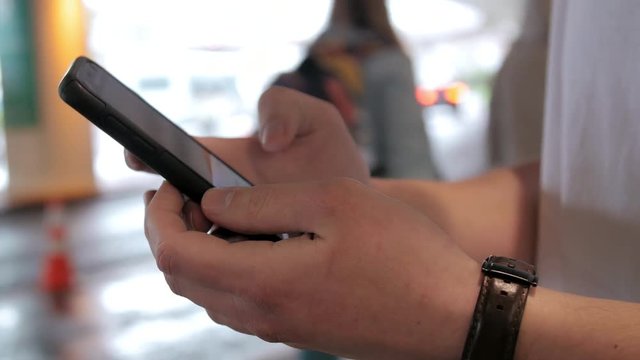 Close up shot of hands using smartphone app to call ride share car at airport