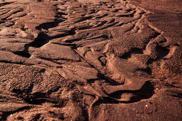 textured pattern in red dirt water trails
