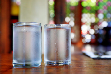 glass of water on wooden table in the morning