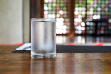 glass of water on wooden table in the morning