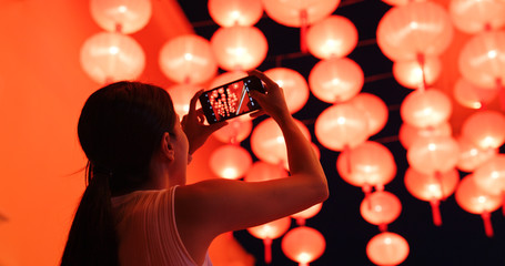 Woman take photo on cellphone with the red lantern