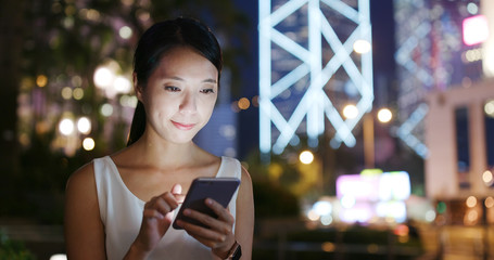 Woman use of mobile phone in city at night