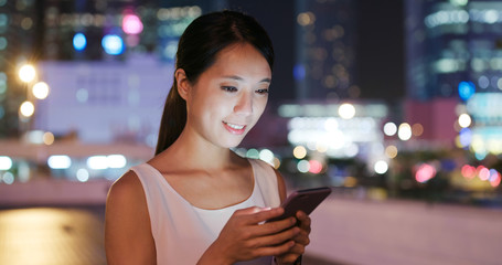 Woman use of mobile phone in the street of Hong Kong