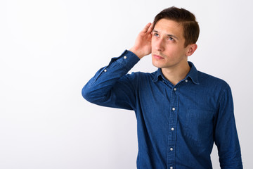 Studio shot of young handsome man listening while thinking again