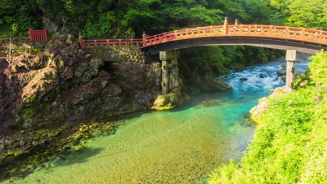 A beautiful morning gorge mist shooting through arch of the Unesco World Heritage Shinkyo Sacred Bridge above the Daiya River with nobody present in Nikko, Japan. Panning 4k time-lapse at 30fps