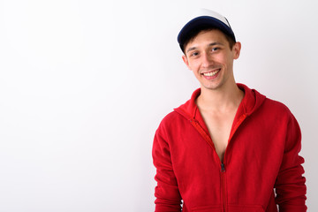 Studio shot of happy young handsome man smiling while wearing ca