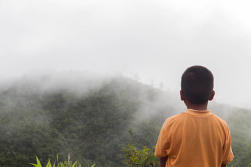 Boys are watching in nature with the mountains view.