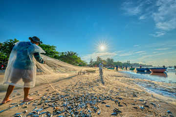 Phan Thiet, Vietnam - September 30th, 2018: Fishermen are doing fishing net after catching as a way of living in the coastal fishing village. This is hard work but many families in Phan Thiet, Vietnam