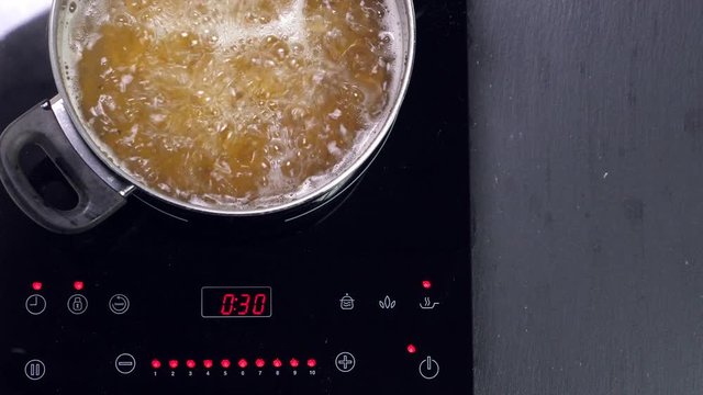 Boiling pasta in pan on induction oven