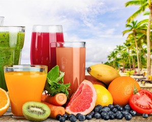 Fresh ripe healthy fruits and juices in glasses