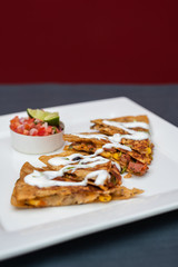 Spanish or Mexican dish Quesadilla served with salad and sauce