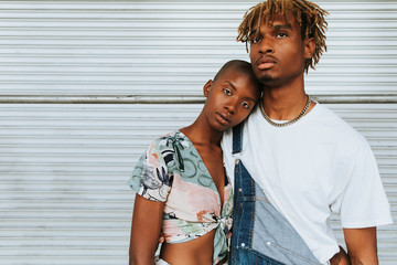 African american couple posing by a wall