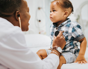 Cheerful pediatrician doing a medical checkup of a young boy