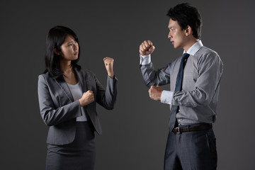対立するビジネスマンとビジネスウーマン