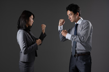 対立するビジネスマンとビジネスウーマン