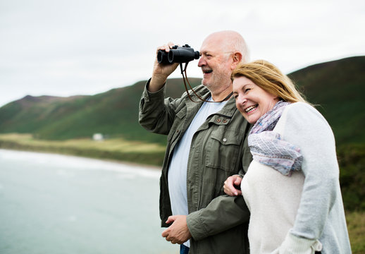 Happy senior couple enjoying with a pair of binoculars - Powered by Adobe