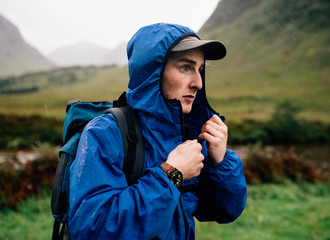 Man zipping up his jacket in the cold