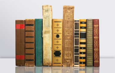 Ancient books in a row on wooden background