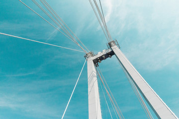 cable-stayed bridge closeup against a blue cloudy sky , abstract structure background
