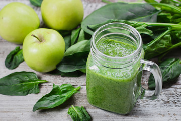 Detox concept. Spinach smoothie in mason jar. Healthy Raw Vegetarian Smoothie on wooden table. Top view, flat lay
