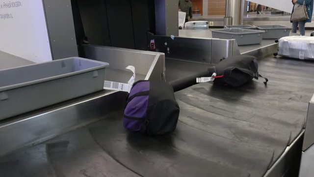Luggage goes on a conveyor belt at the airport.