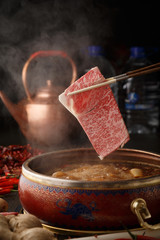 A piece of beef into the hot pot