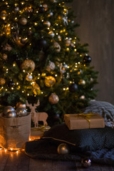 winter decor: Christmas tree,garland,  balls, gifts and cozy striped and gray plaids with pillows. Selected focus