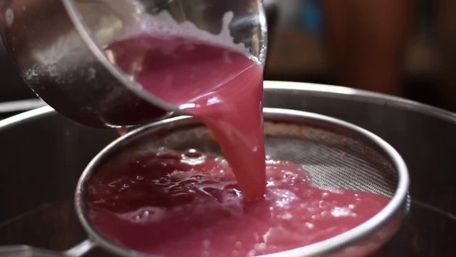 Bignay, Antidesma bunius traditional crude primitive method of home wine processing juice being strained with sieve separating fine pulp residue