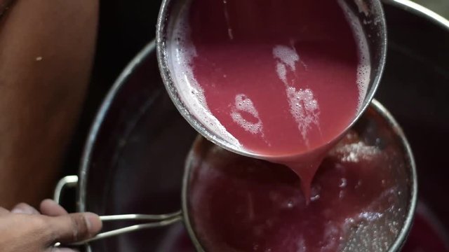 Bignay, Antidesma bunius traditional crude primitive method of home wine processing juice being strained with sieve separating fine pulp residue
