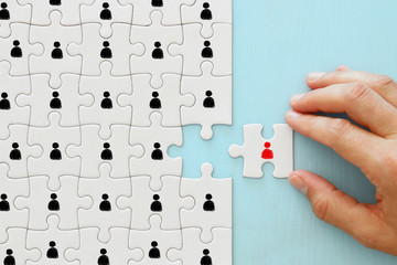 image of puzzle with people icons over wooden table ,human resources and management concept.