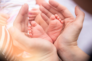 Fototapeta na wymiar Baby feet into mothers hands.Baby feet into mothers hands. Happy Family concept. Beautiful conceptual image of Maternity