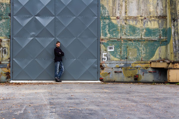 Portrait of young man stand in front of big door, street art photo