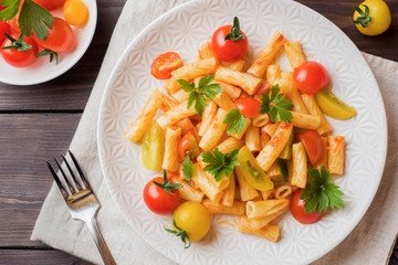 Macaroni, pasta in tomato sauce and cheese in a plate on a wooden table
