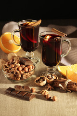 Two cups with ready mulled wine with anise, cinnamon and nuts around