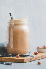 Nut butter chocolate protein shake in a glass jar. The concept of a healthy lifestyle and fitness diet.