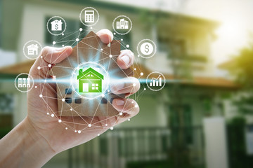 Obraz premium Hand holding model house with property investment icons
