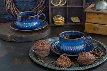 coffee on the table in blue ceramic cups, muffins and an old coffee grinder - coffee background