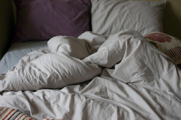 Fototapeta na wymiar Crumpled bedding on the bed