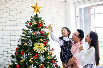 Family decorating a Christmas tree and Father giving Christmas Gift,Christmastime celebration and Happy new year.