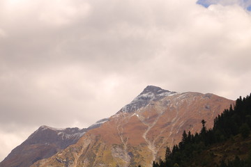 Fototapeta premium Stream flowing between the mountains under the cloudy sky