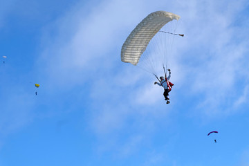 White skydiver is flying in the sky.