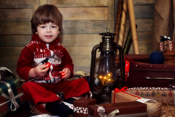 boy dressed in a sweater with Christmas pattern posing at the camera