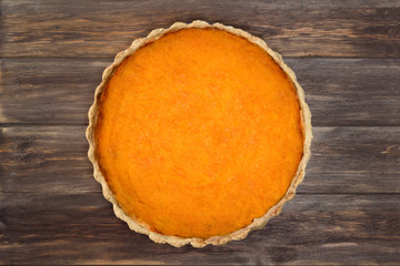 Orange pumpkin pie on wooden background. Thanksgiving Day, culinary, recipe, menu concept. Top view, flat lay, copy space, mock up